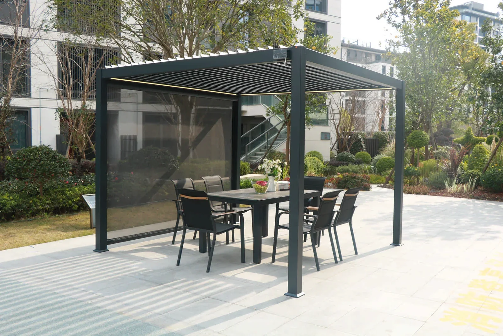 Outdoor dining furniture beneath a louvered pergola