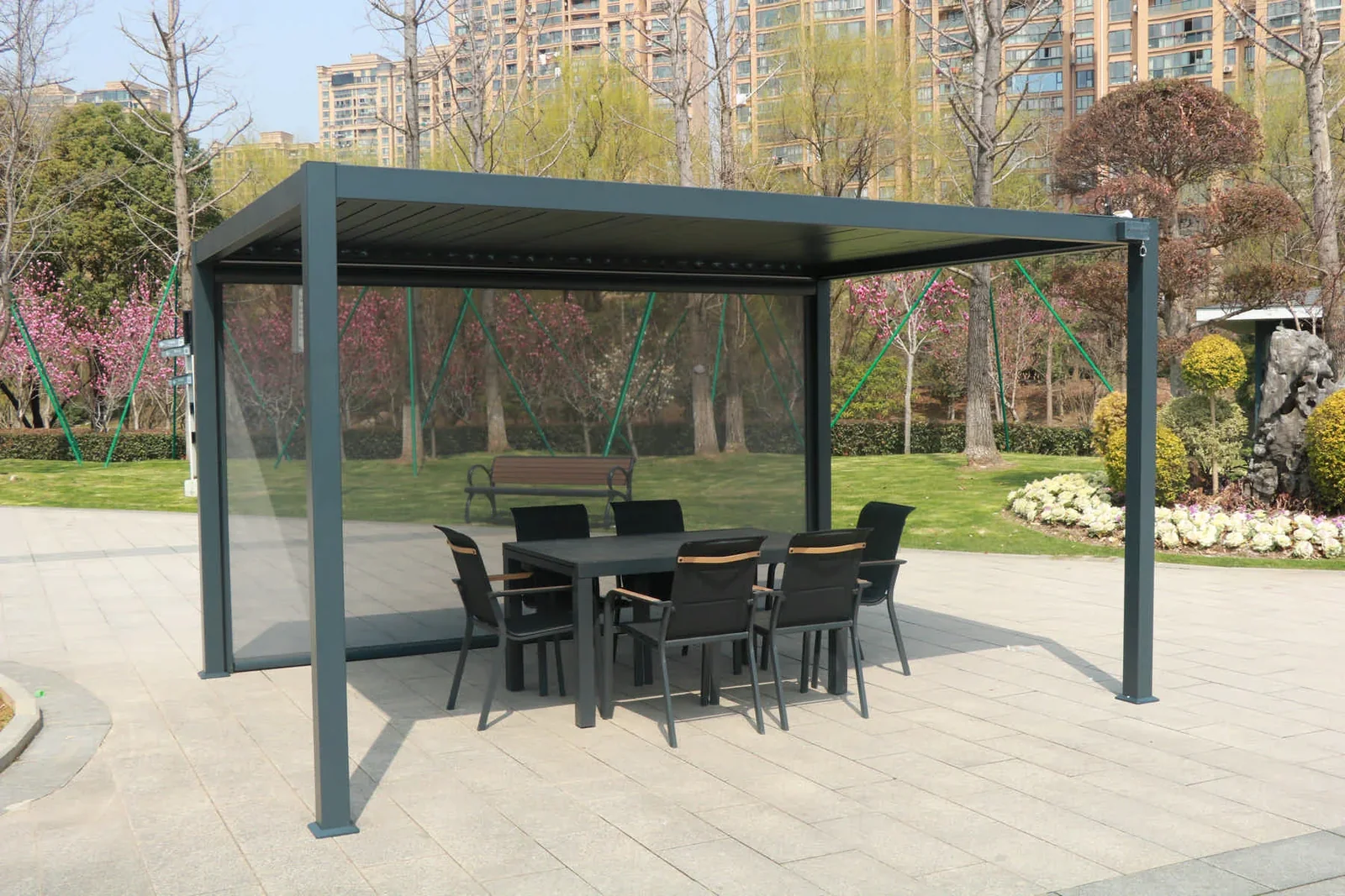Grey louvered pergola installed in a landscaped garden